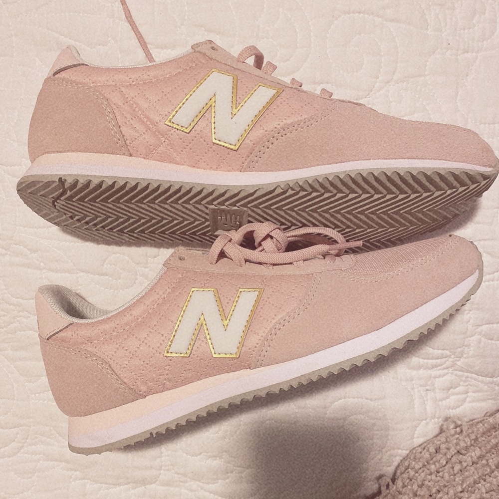 Light pink New Balance tennis shoes.